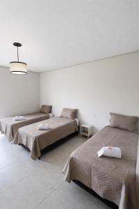 a bedroom with two beds and a pendant light at Pousada Iraquara in João Pessoa