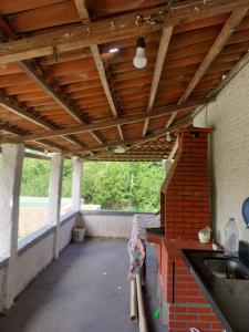 an outdoor kitchen with a wooden ceiling and a brick wall at Sitio de Antonio à 18km do parque do povo in Campina Grande