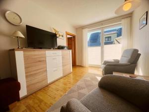 a living room with a flat screen tv and a chair at Ferienwohnung Westi in Thiessow +13 photos