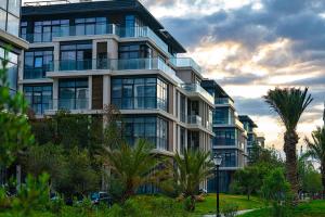 a large building with palm trees in front of it at Sea Breeze Polo Residence in Baku