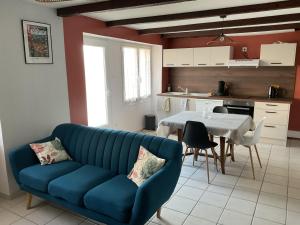 a living room with a blue couch and a table at Maison 6 couchages in Le Monteil