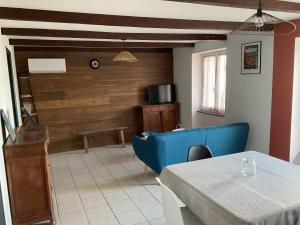 a living room with a blue couch and a table at Maison 6 couchages in Le Monteil