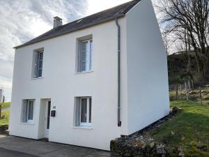 a white house with two windows at Maison 6 couchages in Le Monteil