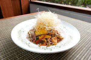 a plate of food with noodles on a table at Hotel Habitel Select in Bogotá
