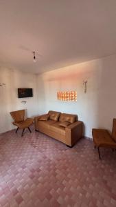 ein Wohnzimmer mit einer Couch und zwei Sesseln in der Unterkunft CasaMajorlândia in Aracati