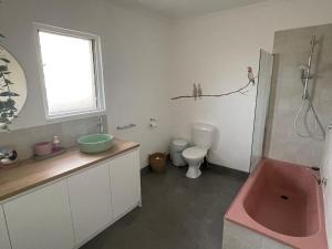 a bathroom with a pink tub and a toilet at Rye Pier Apartment in Rye +7 photos