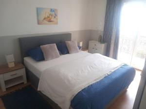 a bedroom with a large bed with blue pillows at Apartman Petra in Senj