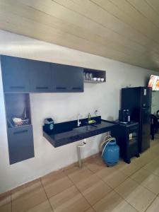 a kitchen with a sink and a refrigerator at Suíte Conforto in Santarém