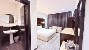 a hotel room with a bed and a sink at اجنحة الطائف للشقق المخدومة - AL Taif Suites in Taif +54 photos