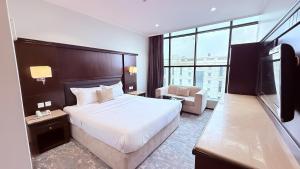 a hotel room with a large bed and a television at اجنحة الطائف للشقق المخدومة - AL Taif Suites in Taif