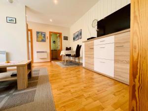 a living room with a large television and a table at Ferienwohnung Boston Terrier in Thiessow +6 photos