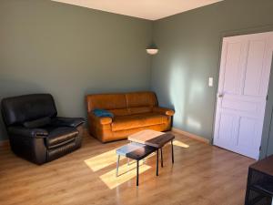 a living room with a couch and a chair at La Parenthèse in Sagy