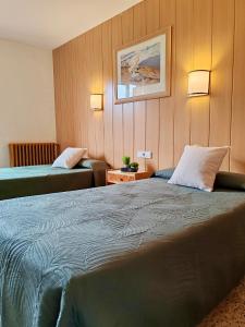 a hotel room with a large bed and a couch at Hotel Acebo & Natura in Castiello de Jaca