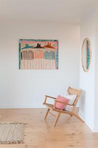 a room with a chair and a painting on the wall at Ocean Views Byron Infused Bliss NEW in Encounter Bay +58 photos