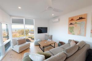 a living room with a couch and a table at Ocean Views Byron Infused Bliss NEW in Encounter Bay