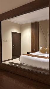 a bedroom with a bed with a large mirror at سما الخليج للشقق المخدومة in Hafr Al-Batin