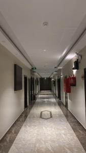 a hallway with a long hallway with ailed floor at سما الخليج للشقق المخدومة in Hafr Al-Batin