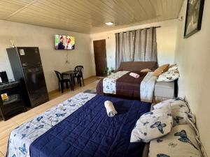 a hotel room with two beds and a table at Suíte Conforto in Santarém