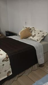 a bed with a blanket on top of it at Suíte Conforto in Santarém