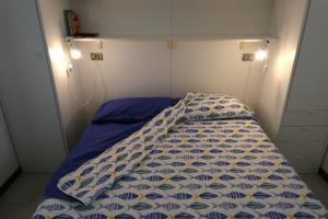 a bed with a blue and white comforter in a room at Casa Onde & Tramonti in Marina di Grosseto