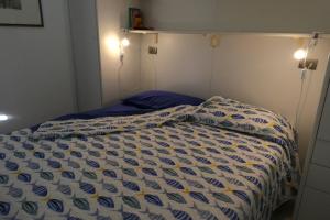 a bed with a blue and white comforter on it at Casa Onde & Tramonti in Marina di Grosseto