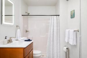 a white bathroom with a sink and a shower at Charming Appleton Condo Downtown Modern Loft in Appleton