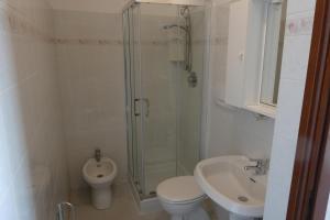 a bathroom with a shower and a toilet and a sink at Casa Onde & Tramonti in Marina di Grosseto +5 photos