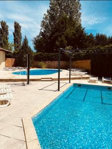 a swimming pool with blue water in a yard at mobil-home in Souméras