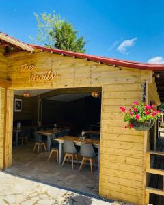 a wooden building with tables and chairs and flowers at mobil-home in Souméras