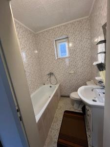 a bathroom with a tub and a toilet and a sink at Річкова Поляна in Polyana