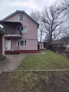 a large house with a large yard in front of it at Річкова Поляна in Polyana