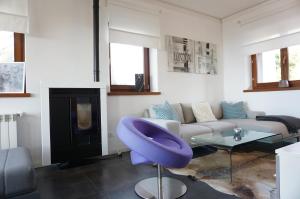 a living room with a couch and a purple chair at Casa Vista Mare in Muggia