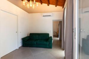 eine grüne Couch in einem Wohnzimmer mit einer Decke in der Unterkunft Itria Palace in Ragusa