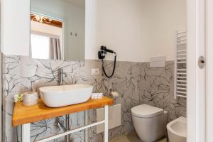 ein Badezimmer mit Waschbecken und Toilette in der Unterkunft Itria Palace in Ragusa