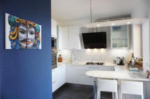 a kitchen with a painting of a face on the wall at Casa Vista Mare in Muggia