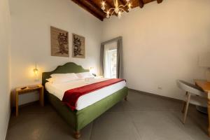ein Schlafzimmer mit Bett, Schreibtisch und Fenster in der Unterkunft Itria Palace in Ragusa