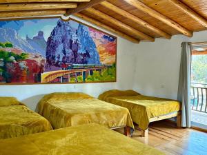 a room with three beds and a painting on the wall at Cabañas las Gemelas in Areponapuchi