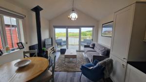 a living room with a couch and a table at Lakeside Retreat, The Bay Filey, 2 bedrooms with ensuites, parking with EV charger in Filey