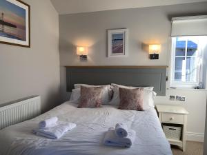 a bedroom with a bed with towels on it at Lakeside Retreat, The Bay Filey, 2 bedrooms with ensuites, parking with EV charger in Filey +24 photos