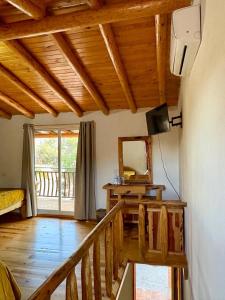 a living room with a wooden staircase and a television at Cabañas las Gemelas in Areponapuchi +34 photos