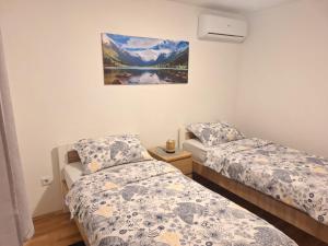a bedroom with two beds and a painting on the wall at Apartment Silvia Zagreb- Free Private Parking, in Zagreb +7 photos