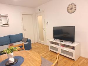 a living room with a flat screen tv and a table at Apartment Silvia Zagreb- Free Private Parking, in Zagreb