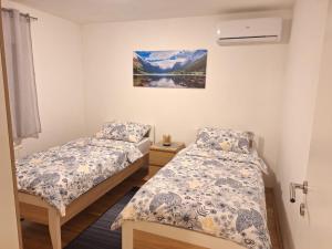 a bedroom with two beds and a picture on the wall at Apartment Silvia Zagreb- Free Private Parking, in Zagreb