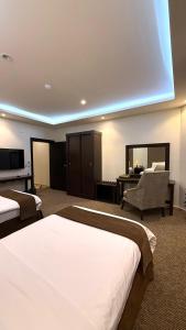 a hotel room with two beds and a mirror at شقق بوابة العالية للشقق الفندقية in Medina