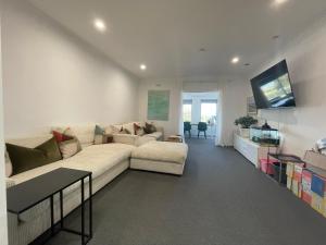 a living room with a white couch and a flat screen tv at Rye Pier Apartment in Rye