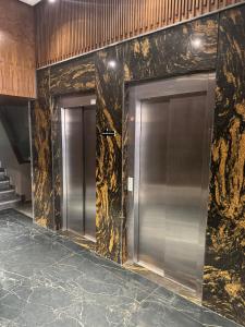 a row of elevators in a building with marble walls at Studio luxueux avec vue panoramique sur le centre ville in Fez