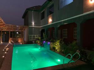 a swimming pool in a yard at night at Exodus Hotel & Restaurant in Aiyetoro