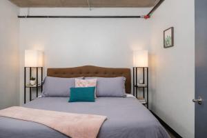 a bedroom with a large bed with two lamps at Downtown Appleton Condo 2 Bedroom Loft Sleeps 6 in Appleton
