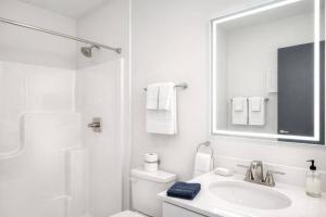 a white bathroom with a sink and a mirror at Downtown Appleton Condo 2 Bedroom Loft Sleeps 6 in Appleton