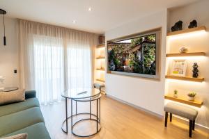 a living room with a table and a tv on a wall at Geysotur Ribera Luxury Suites in Córdoba